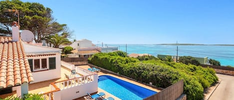 Ein Wohnhaus mit Swimmingpool, einem Balkon mit Meerblick und einer Satellitenschüssel.