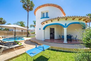 Ein zweistöckiges Gebäude mit Pool, Außenbereich und Tischtennisplatte.