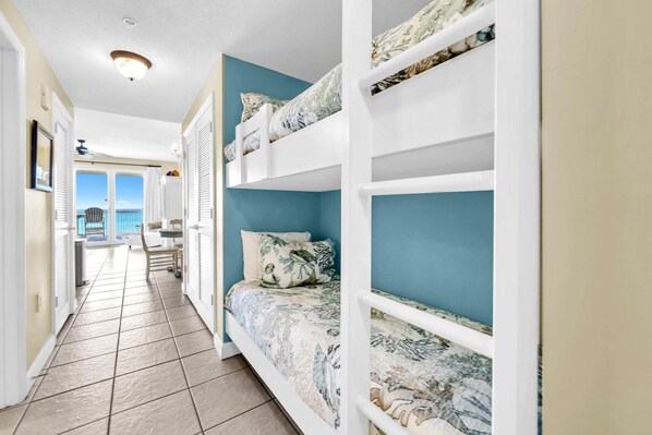 A room with bunk beds, a view of the sea, and a tiled floor. - Seychelles 602 (Panama City Beach)