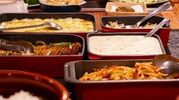 A buffet table with various dishes and utensils.