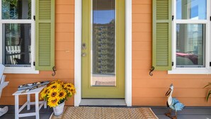 A house with a green door, green shutters, and a bird statue on the porch. - The Grand Castle (Panama City Beach)