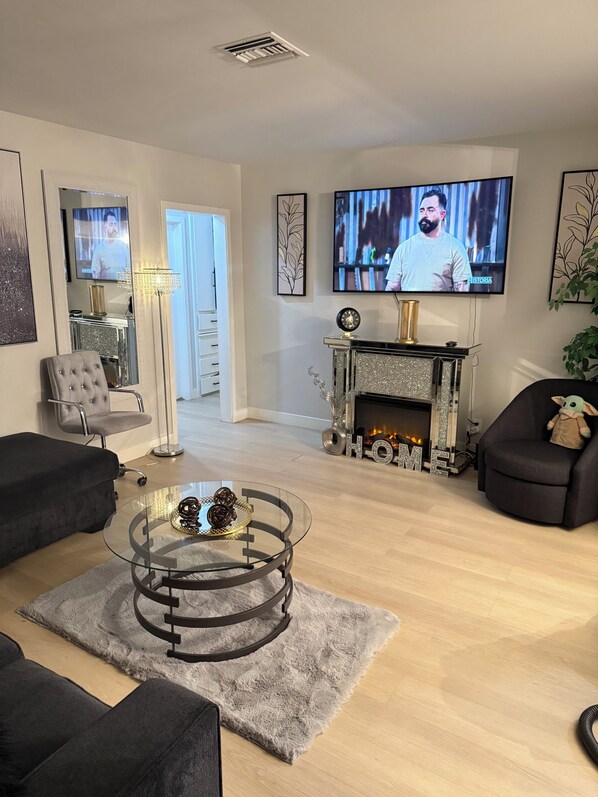 A living room with a fireplace, a television, and modern furniture. - Relaxing Cozy Back House with Backyard (Upland)