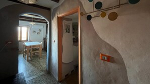 Ein Zimmer mit einem Holztisch, Stühlen, einem Deckenventilator und einer Wandleuchte.