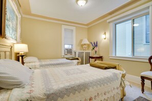 A hotel room with two beds, a desk, a lamp, a window, and a painting on the wall. - Walk to the Walker Art Center! Apt in Lowry Hill (Minneapolis)