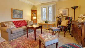 A cozy living room with a sofa, armchair, ottoman, and a wooden cabinet. - Walk to the Walker Art Center! Apt in Lowry Hill (Minneapolis)
