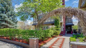 A building with a stone pathway leading to the entrance, surrounded by greenery and a clear sky. - Walk to the Walker Art Center! Apt in Lowry Hill (Minneapolis)