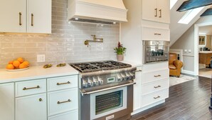 A modern kitchen with white cabinetry, a gas stove, and a built-in oven. - Summer Beach Pass: Wooded Martha's Vineyard Escape (Vineyard Haven)