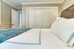 A bedroom with a bed, a door, and a closet. - Summer Beach Pass: Wooded Martha's Vineyard Escape (Vineyard Haven)
