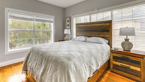 A bedroom with a wooden bed, a nightstand, a lamp, and a ceiling fan. - Apt Near Hermann Park & TMC - Free Parking Spot! (Houston)