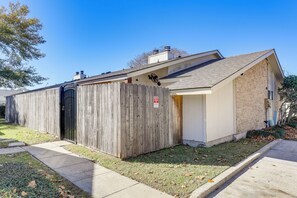 A single-story building with a wooden fence, a garage door, and a small attached shed. - 1/2 Mi to Hospitals: Updated Baton Rouge Stay (Baton Rouge)