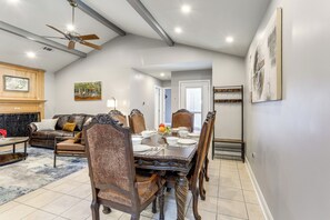 A dining area with a large table set for six, surrounded by ornate chairs. There is a ceiling fan above and a fireplace with a mantel to the left. - 1/2 Mi to Hospitals: Updated Baton Rouge Stay (Baton Rouge)