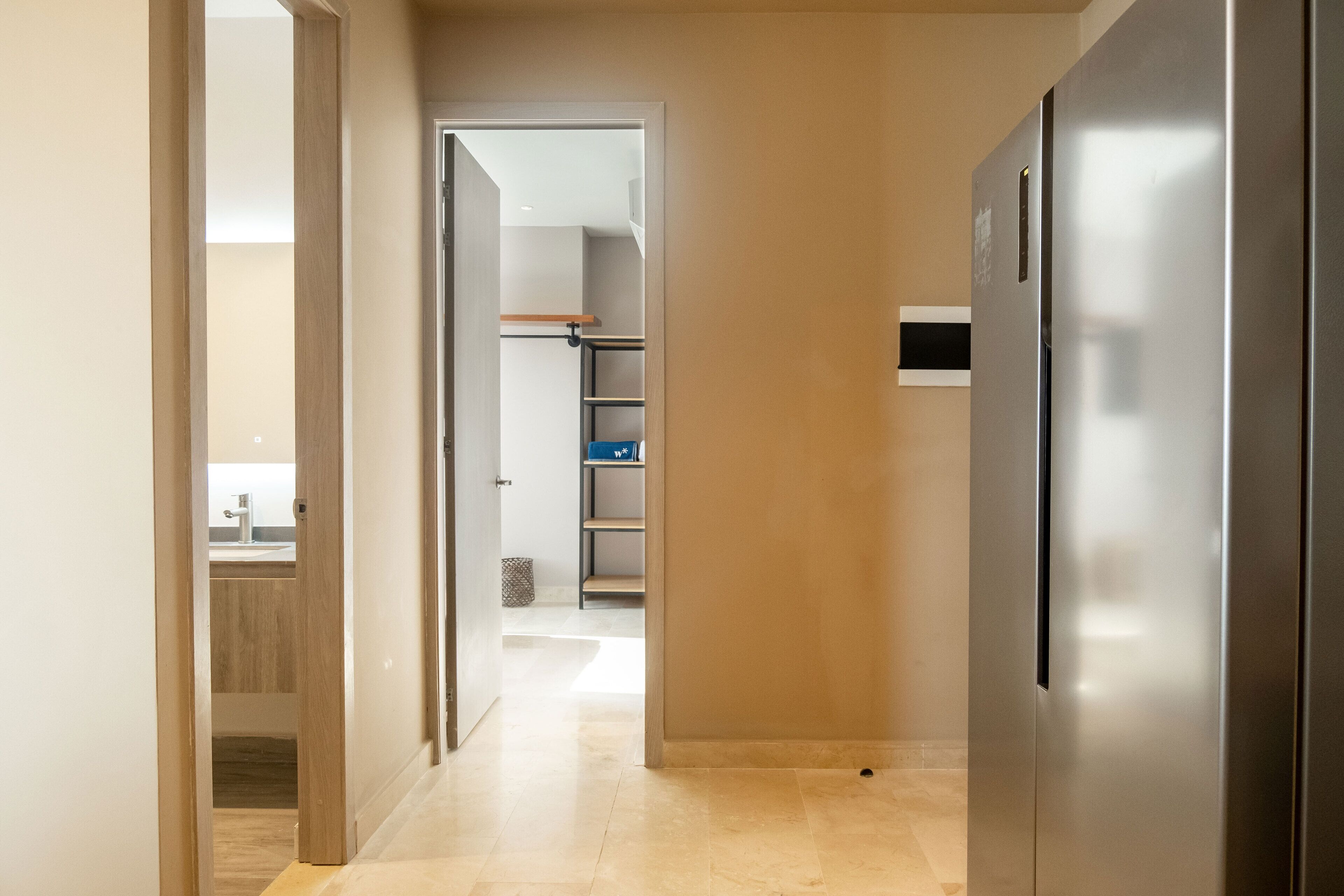 Una cucina moderna con frigorifero in acciaio inox, mobili in legno e un piano di lavoro a vista.