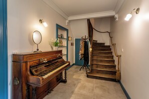 Ein Flügel, ein Spiegel, eine Treppe mit Seilhandlauf und eine blaue Tür.