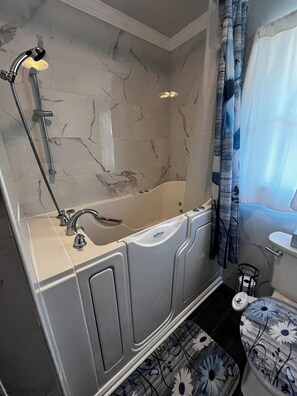 A bathroom with a bathtub, a shower, a toilet, and a sink. - Spacious 4-bedroom house in charming Bluff City (Bluff City)