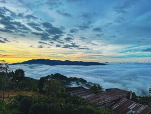 A mountainous landscape with a view of clouds below and a clear sky above. - Rio Skyhouse (Xuan Truong - Da Lat)