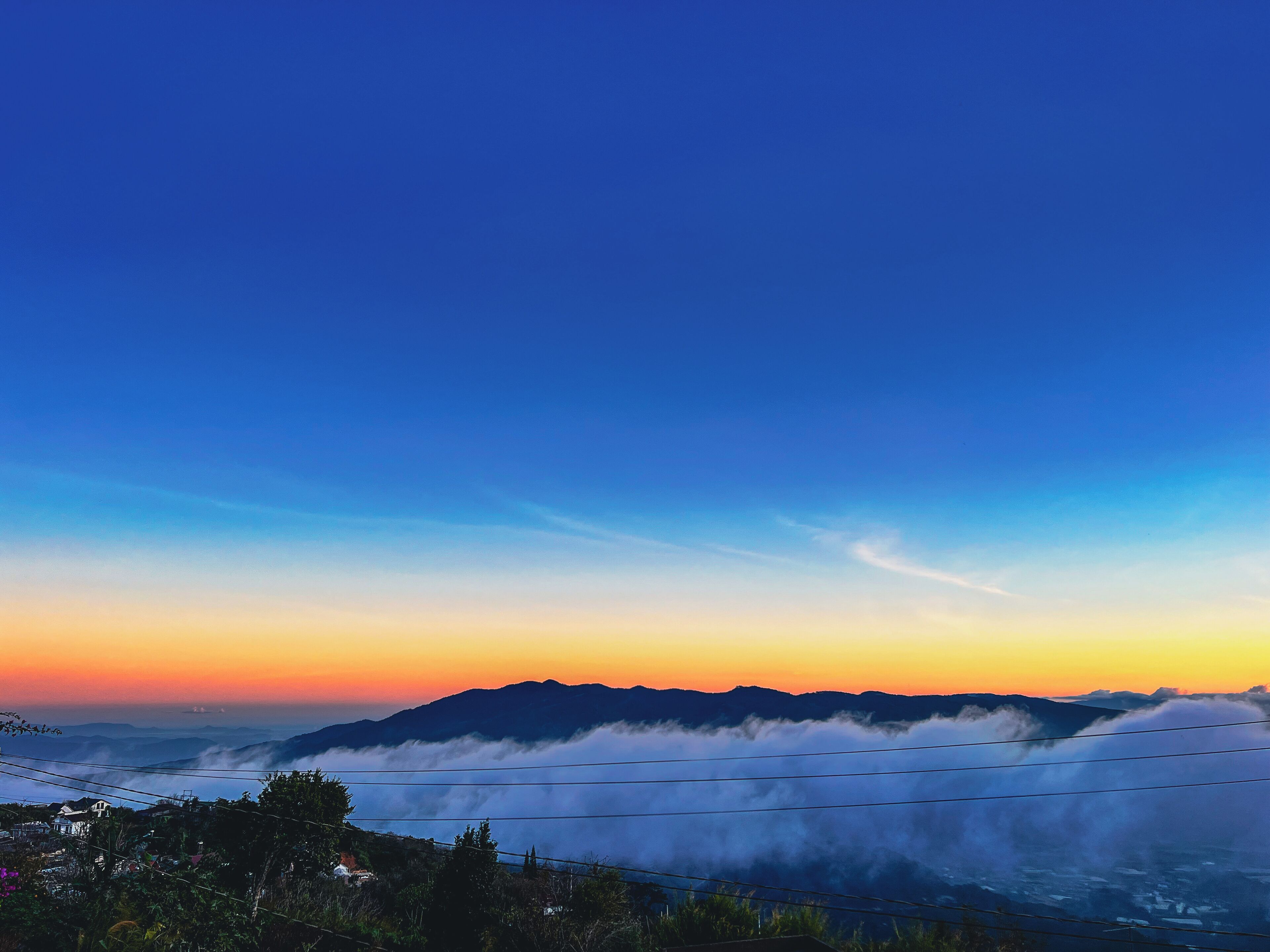 A mountainous landscape with a clear sky and a view of a valley below.