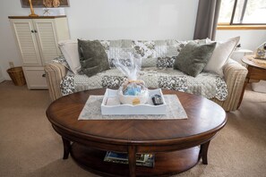 A round wooden coffee table with a tray in front, a wicker basket, and a remote control. - Charming 1-bedroom cottage perfect for a relaxing Durango getaway (Durango)