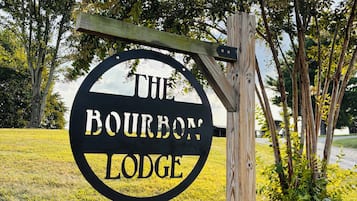 A circular sign with the text 'THE BOURBON LODGE' mounted on a wooden post.