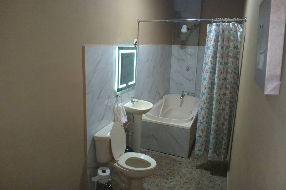 A bathroom with a toilet, sink, and bathtub.