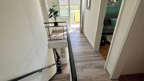 Una escalera con barandilla que lleva a una habitación con cama y ventana.
