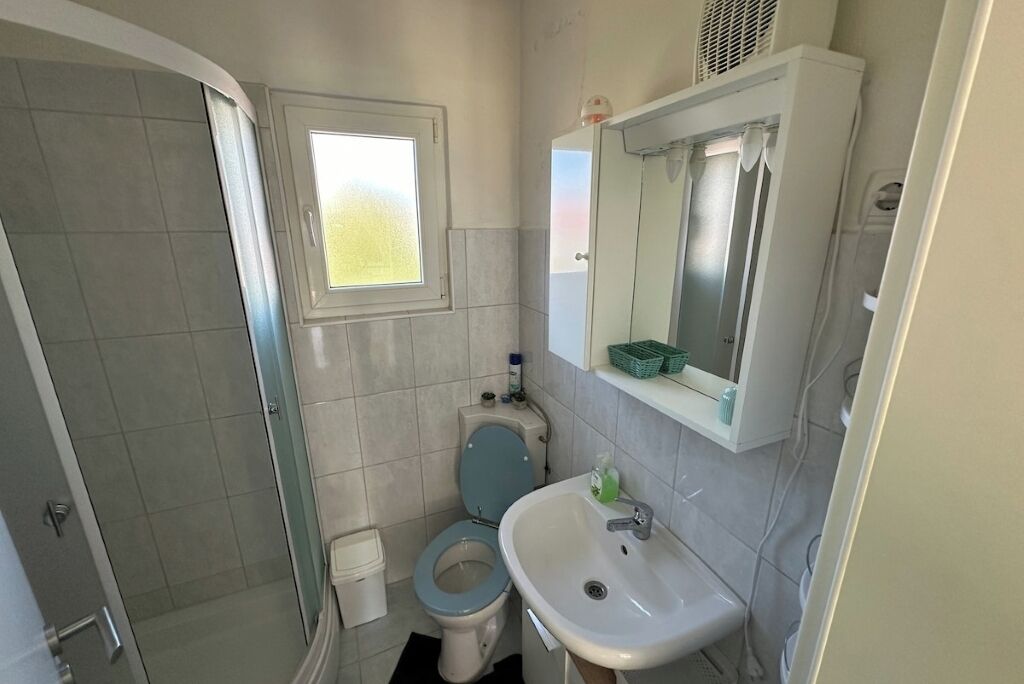 Un baño pequeño con inodoro, lavamanos y ducha.