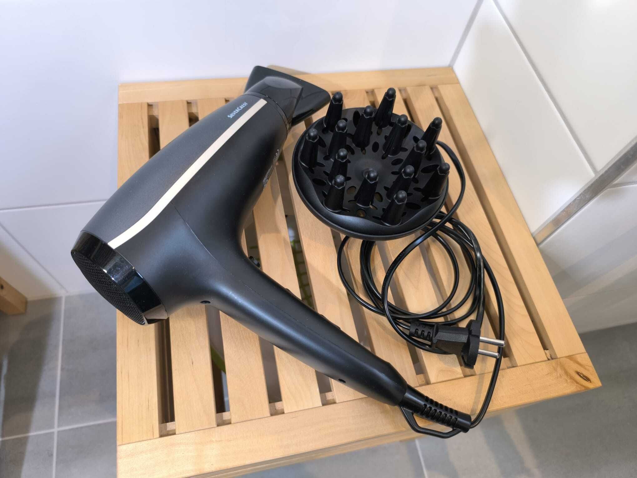A hair dryer and its accessories on a wooden tray.