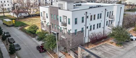 A modern multi-story building with a flat roof, large windows, and a brick facade.