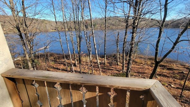 A wooden balcony with a view of a lake and trees. - LAKEFRONT 5-bedroom Chateau Getaway at Whitecap Mountains Resort Units 1 & 3 (Upson)