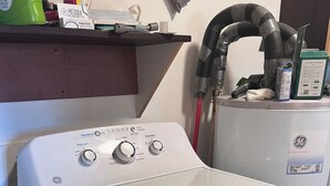 A front-loading white washer with control knobs, a red fire extinguisher, and a GE dryer in the background. - Kid & Pet-Friendly Rainbow Cottage in the Heart of Arco (Arco)