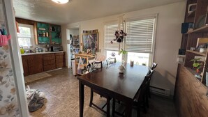 A kitchen with a dining table, chairs, and a hanging plant. - Kid & Pet-Friendly Rainbow Cottage in the Heart of Arco (Arco)