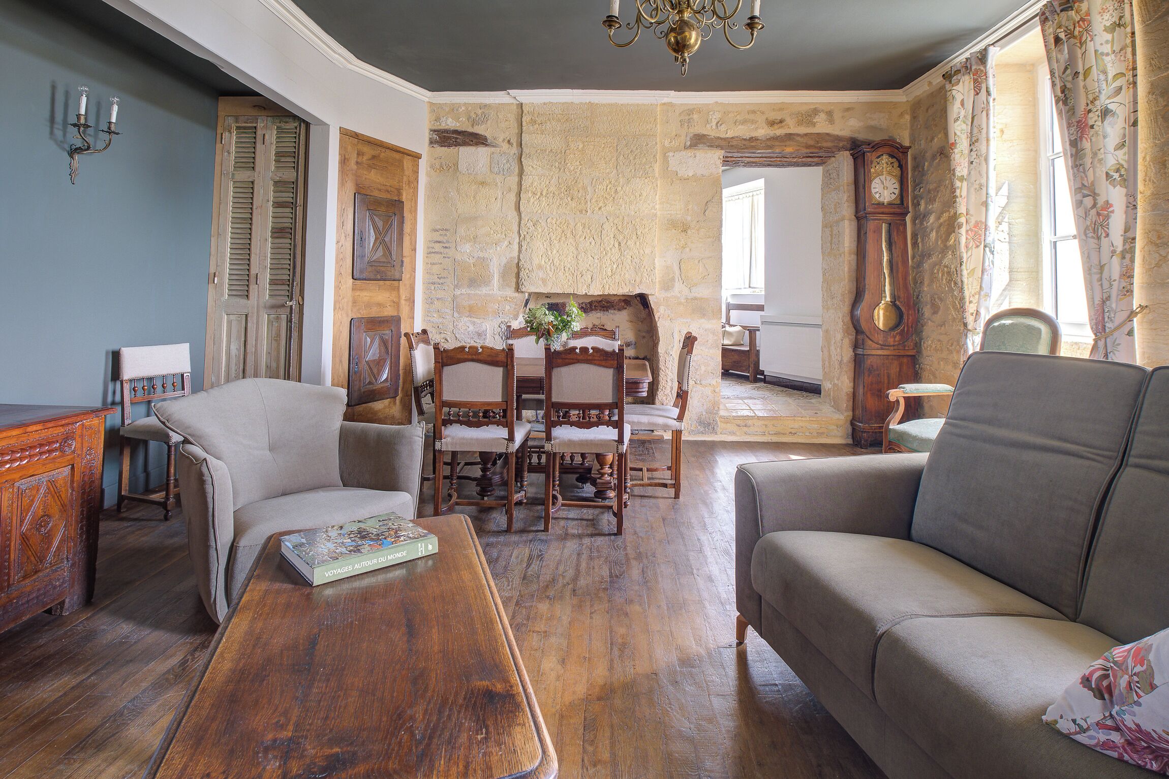 Un salon chaleureux avec une table basse en bois, un canapé et un coin repas comprenant des chaises et une table en bois.