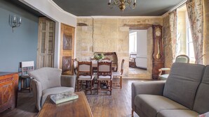 Uma sala de estar acolhedora com uma mesa de centro de madeira, um sofá e um espaço de jantar com cadeiras e mesa de madeira.
