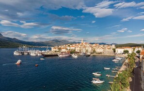 A coastal town with a marina filled with boats, historic buildings, and a clear sky. - Beach front home in Blato (Blato)