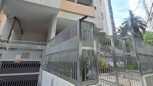 Un edificio alto con diversi piani, un ingresso con cancello e un cielo sereno.