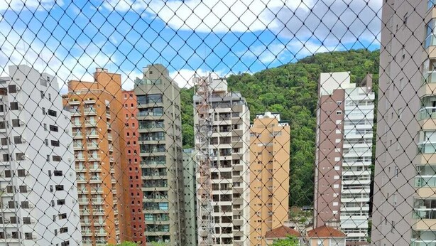 Un balcone con due sedie di legno e un tavolino rotondo con un vassoio di cibo e bevande.