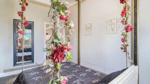 Een kamer met een bed, een spiegel en wanddecoratie.