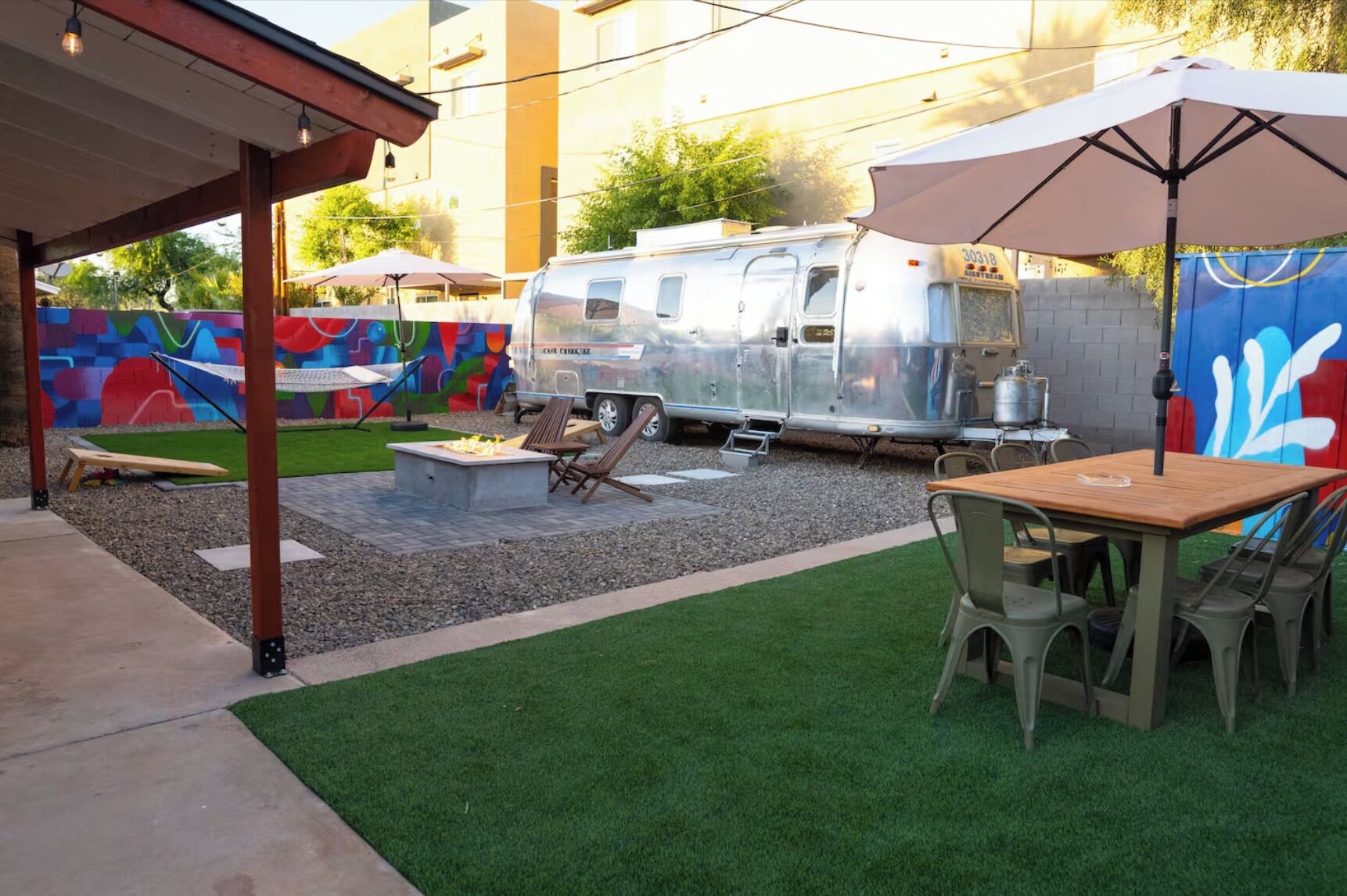 Terrassa exterior amb una barbacoa, seients i una caravana.