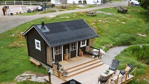 Een chalet met terras, een hottub en een klein zitgedeelte buiten.