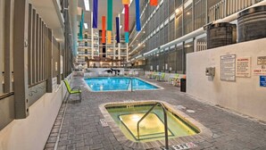Un área de piscina interior con dos piscinas, una sauna y un espacio de descanso con sillas y mesas.