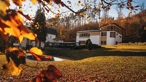 A modern house with a large deck and a swimming pool, surrounded by autumn foliage. - Penzion U Libuše (Luleč)