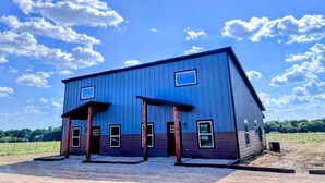 A two-story building with a flat roof, a front porch, and a gravel driveway. - 99 per Night - New home next to KimberlyClark.662 - cleaning &taxes not included (Paris)