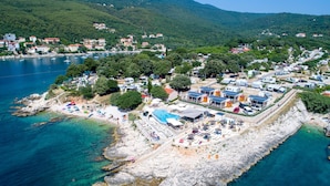 Un complejo turístico frente al mar con piscina, playa y villas.
