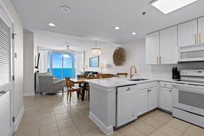A modern kitchen with white cabinetry, a built-in dishwasher, and a large island. - 2 Bedroom Lighthouse w/ Bunk , 3 Pools! Direct Beachfront. Free Daily Activities (Gulf Shores)
