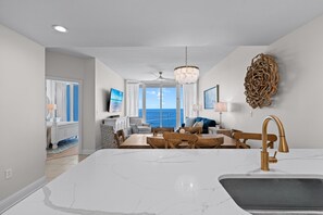 A modern kitchen with a marble countertop, a gold faucet, and a view to the ocean. - 2 Bedroom Lighthouse w/ Bunk , 3 Pools! Direct Beachfront. Free Daily Activities (Gulf Shores)