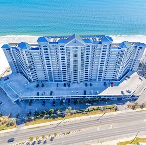 A high-rise hotel with multiple floors, a parking garage, and a beachfront location. - 2 Bedroom Lighthouse w/ Bunk , 3 Pools! Direct Beachfront. Free Daily Activities (Gulf Shores)