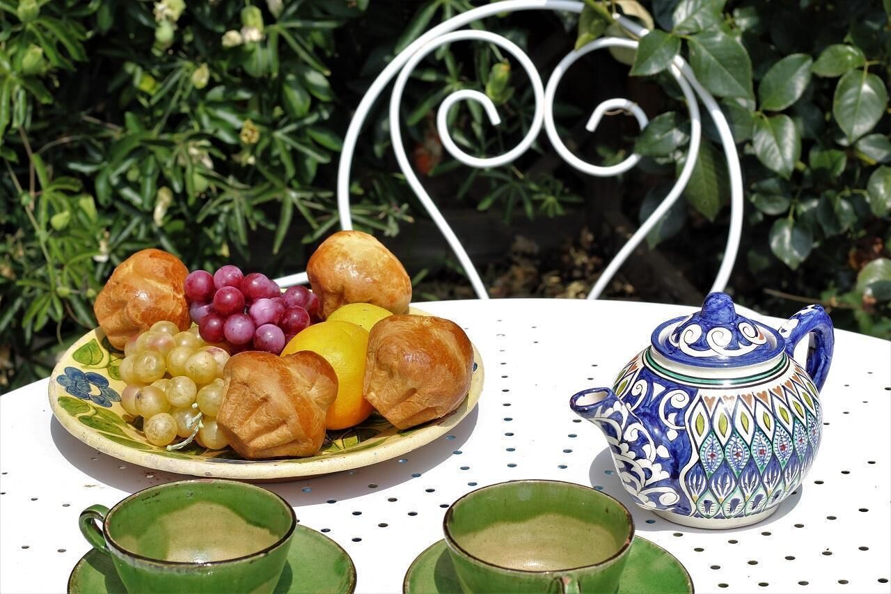 Une table avec une assiette de nourriture, une théière et deux tasses.