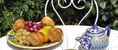 Une table avec une assiette de nourriture, une théière et deux tasses.
