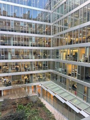 En kontorsbyggnad med flera våningar, många fönster av glas och en central atriumgård.