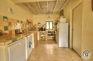 A compact kitchen with a washing machine, a coffee maker, and a refrigerator. - Le Clos des Rues - ARNAS (ARNAS)