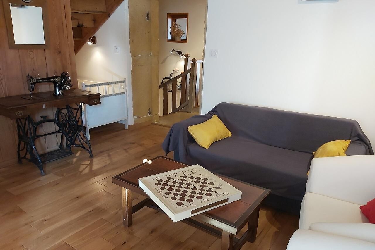 Un salon avec un canapé, un jeu d’échecs et une machine à coudre.